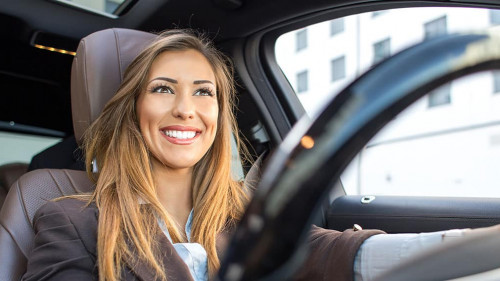Beautiful businesswoman smiling in a car