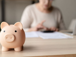 Toy pink piggy bank on work table of senior tenant