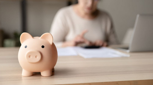 Toy pink piggy bank on work table of senior tenant