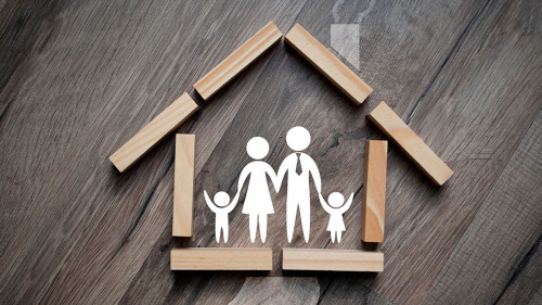 House made of wooden pieces with family stick figures on wooden