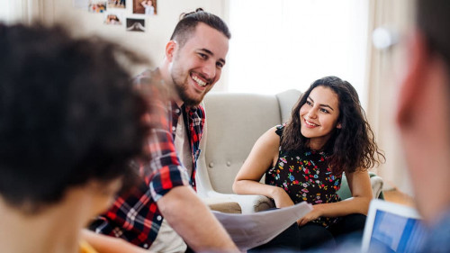 A group of young friends with laptop indoors, house sharing concept.