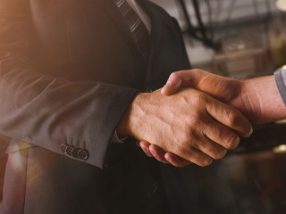 Handshaking of business person in office as teamwork and partnership