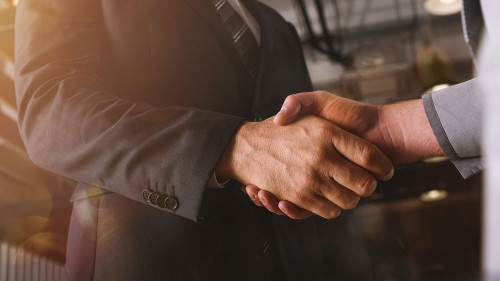 Handshaking of business person in office as teamwork and partnership