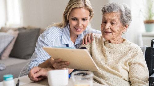 A health visitor measuring a blood pressure of a senior woman at home.
