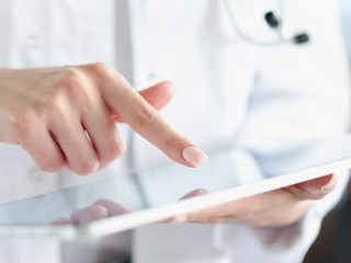 Medical officer doctor points his finger at tablet