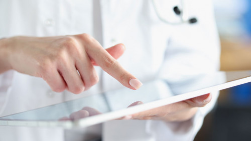 Medical officer doctor points his finger at tablet