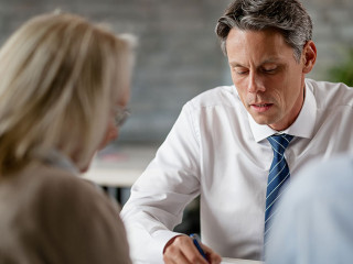 Anzugtraeger-Paar-Beratung-298880685-AS-Drazen