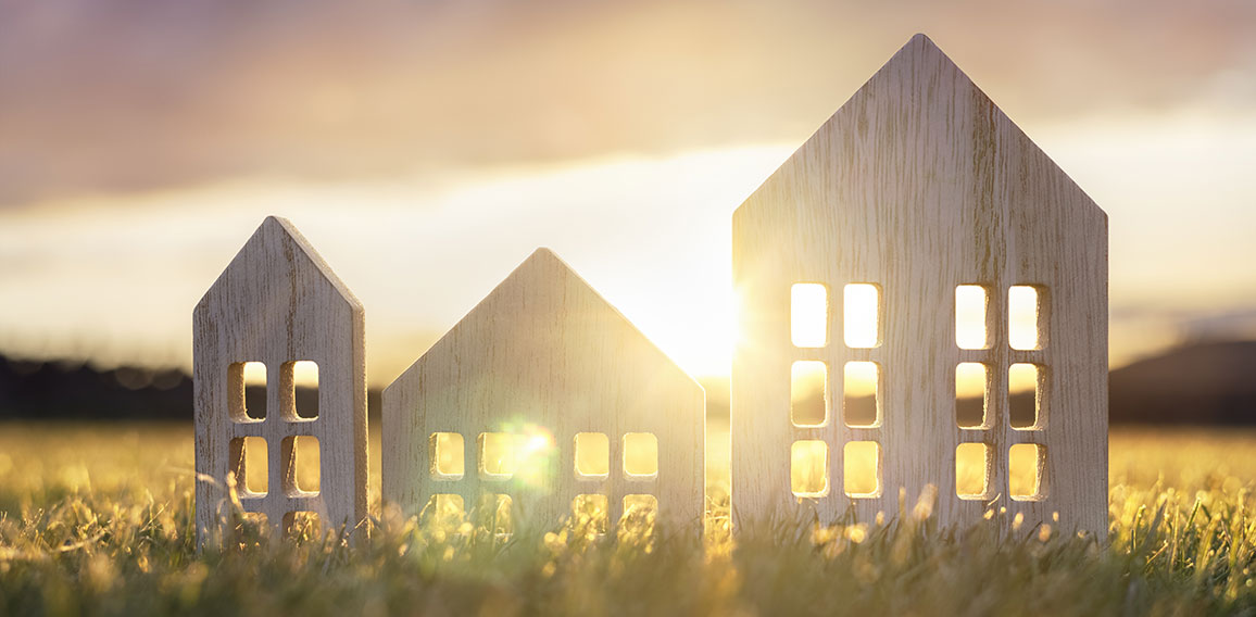 Ecological wood  model house in empty field at sunset