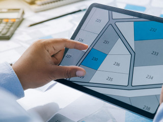 Man holding a tablet looking at lots of lands. Land plot managem