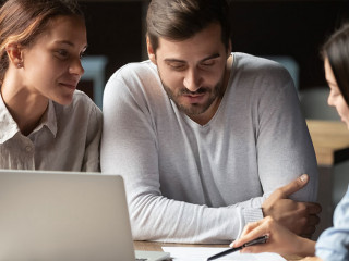 Young couple meeting with relator in cafe