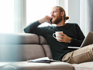 Mann-Couch-Laptop-Telefon-236965756-AS-Drobot-Dean