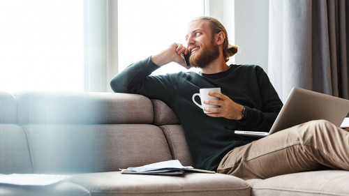 Mann-Couch-Laptop-Telefon-236965756-AS-Drobot-Dean