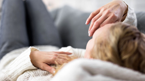 Frau-krank-Sofa-315011756-AS-astrosystem