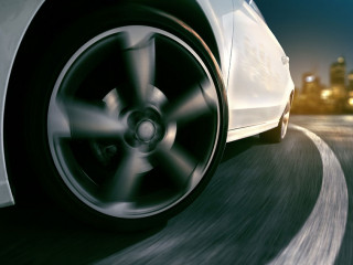 Auto fährt durch Kurve bei Nacht