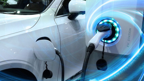 EV Car or Electric vehicle at charging station with the power cable supply plugged in on blurred nature with blue energy power effect. Eco-friendly sustainable energy concept.