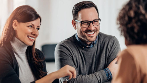 Happy couple talking with sales manager