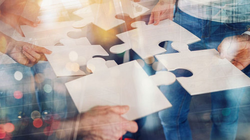 Teamwork of partners connect puzzle pieces as integration and startup