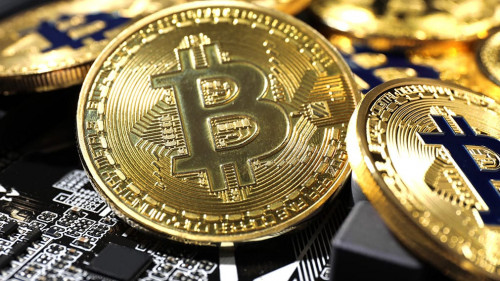 Golden bitcoins on computer circuit board, closeup