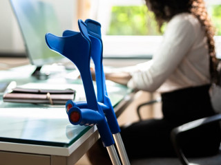 Kruecken-Frau-Office-441728412-AS-Andrey-Popov