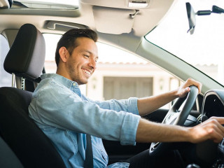 Attractive male driver using the GPS navigation map on the car