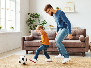 Father and son playing football at home