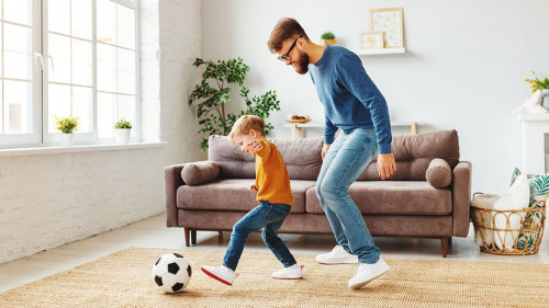 Father and son playing football at home