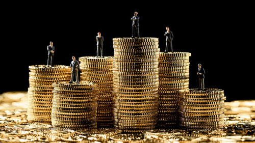 高く積み重ねたコインの上にミニチュアのビジ