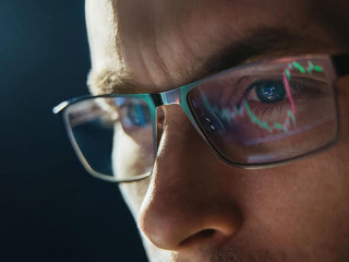 Portrait of trader wearing eyeglasses with reflection cryptocurrency chart