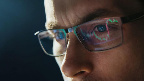Portrait of trader wearing eyeglasses with reflection cryptocurrency chart