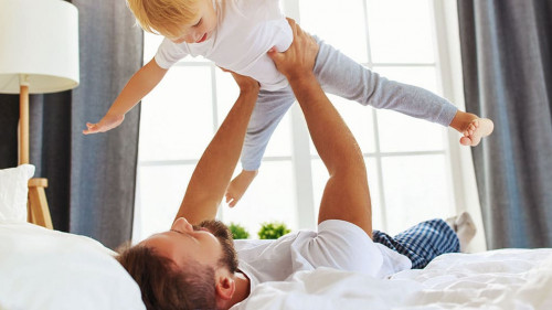 happy family father and child son at home in bed