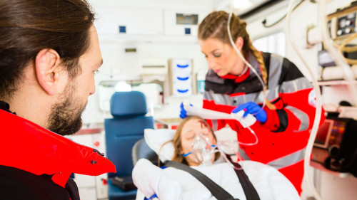 Ambulance helping injured woman with infusion