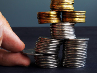 Financial Stability concept. Man holding coin in the coins stack.