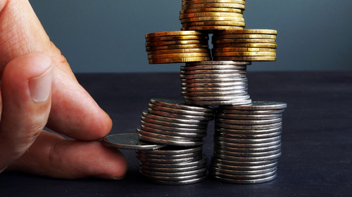 Financial Stability concept. Man holding coin in the coins stack.