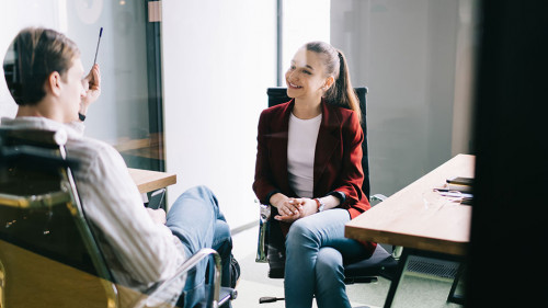 Cheerful office workers talking behind glass door