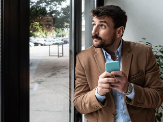 Young business man waiting for the taxi or cab that he called or