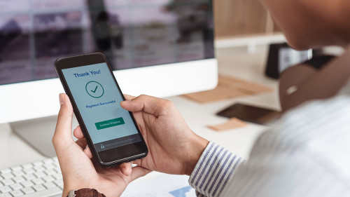 Man's hands holding smartphone and successful online payment. Mobile wallet payment concept.