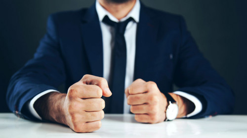 man fists on table