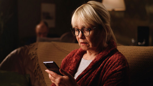 Scared aged woman reading shocking news