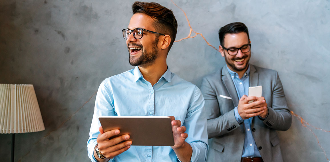 Young smiling successful business man, entrepreneur in formal business suite working on tablet