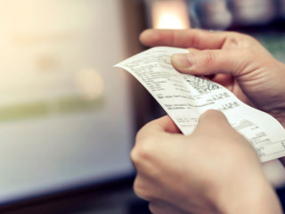 the girl looks at the receipt in the store