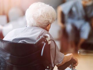 Thoughtful senior man sitting on wheelchair at hospital. Sad dis