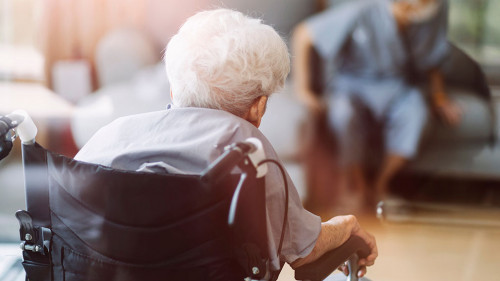 Thoughtful senior man sitting on wheelchair at hospital. Sad dis