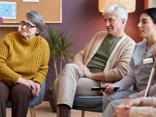 Elderly people watching TV in retirement home together