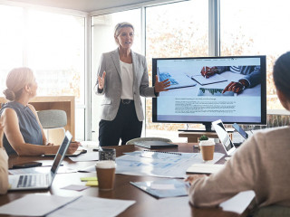 Business leader, woman and slideshow at team building seminar for company growth. Working, market research data and workshop of a female manager meeting with marketing group in office with tech