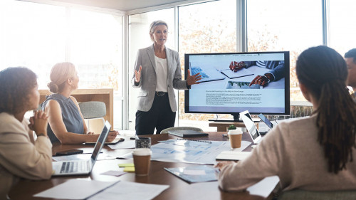 Business leader, woman and slideshow at team building seminar for company growth. Working, market research data and workshop of a female manager meeting with marketing group in office with tech