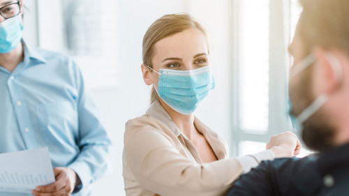 Business people doing corona bump to greet each other in meeting