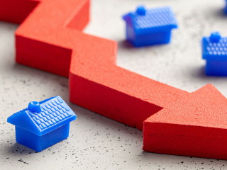 House and red arrow down. Falling real estate prices. Reduced in