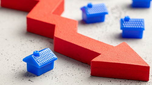 House and red arrow down. Falling real estate prices. Reduced in