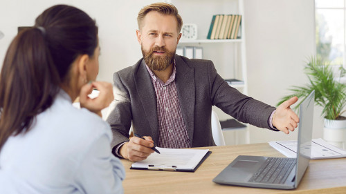 Male manager provides advice to female client and acquaints her with terms of contract.