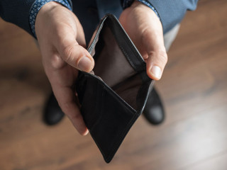 Well dressed man holding empty leather wallet. Financial crisis and bankruptcy concept